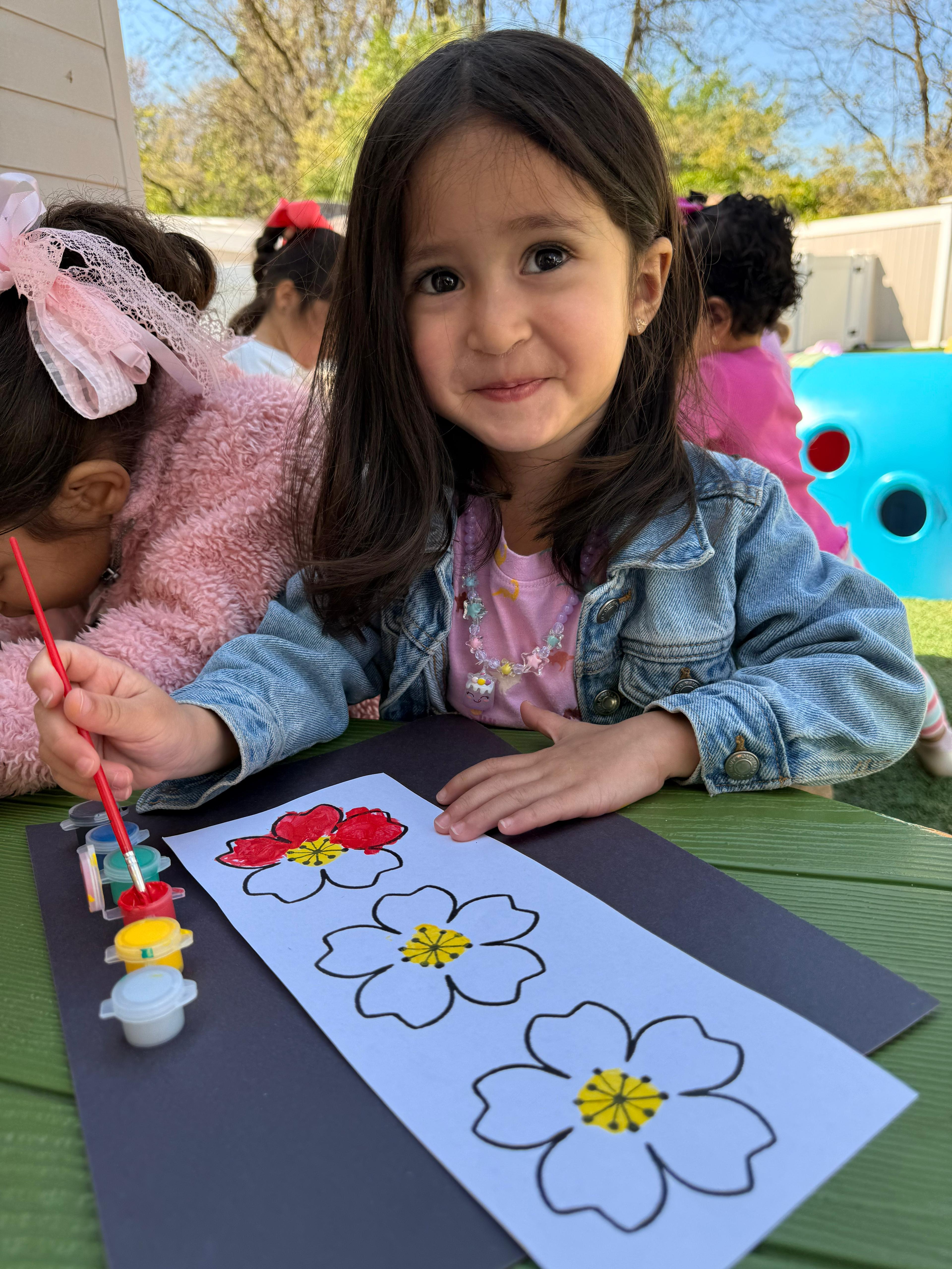 Children doing outdoor flower painting arts and crafts